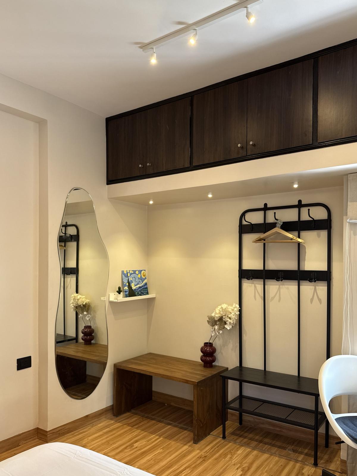 A wavy mirror on a bedroom wall